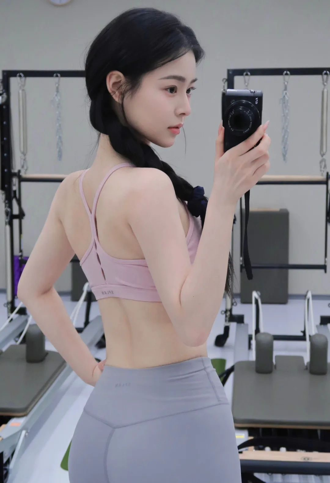 灰色瑜伽裤勾勒完美线条，搭配粉色露脐上衣，粉嫩中带点小性感